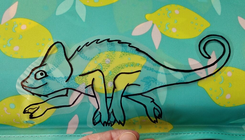 Kameleon wtapiajacy sie w tło z namalowanymi cytrynkami